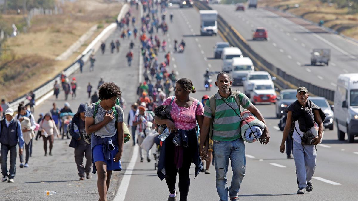 Migrantes avanzan por la autopista Puebla-México. Foto: EFE